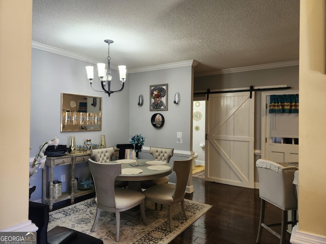 dining room with dark wood finished floors, a chandelier, a barn door, and ornamental molding