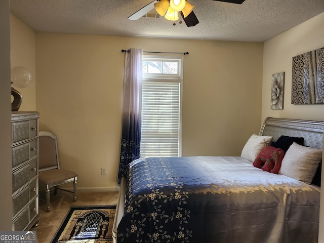 carpeted bedroom with baseboards, visible vents, a textured ceiling, and a ceiling fan