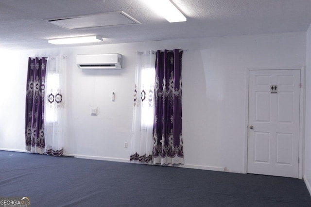 carpeted empty room with a textured ceiling and a wall unit AC