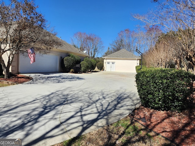 view of home's exterior featuring an outbuilding, stucco siding, driveway, and a garage