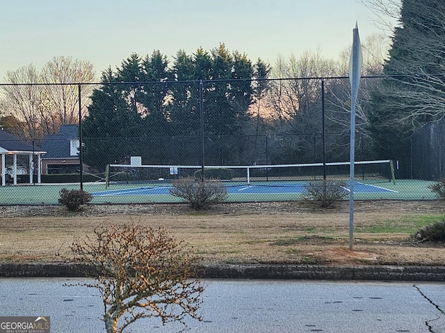 exterior space featuring a tennis court and fence