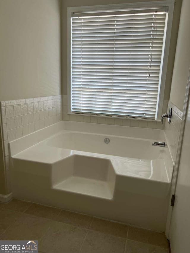 full bath featuring tile patterned flooring and a garden tub