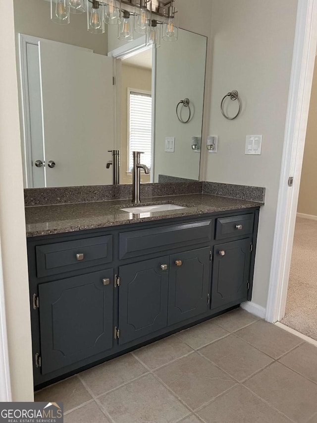 bathroom with tile patterned flooring, vanity, and baseboards