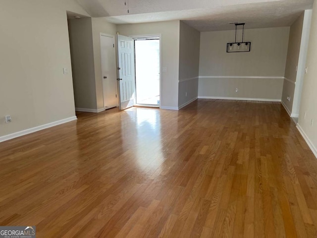 spare room featuring wood finished floors and baseboards