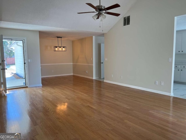 unfurnished living room featuring ceiling fan, wood finished floors, visible vents, and baseboards