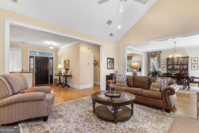 living room featuring high vaulted ceiling, visible vents, baseboards, and wood finished floors