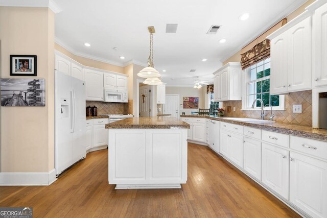 1020 Troublesome Creek Ln, Greensboro, GA 30642 - kitchen with crown molding, white cabinets, a sink, white appliances, and a center island