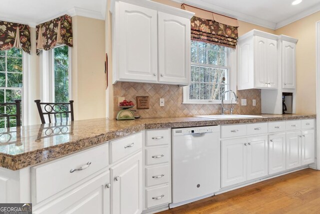 kitchen with ornamental molding, a healthy amount of sunlight, white cabinetry, a sink, and dishwasher