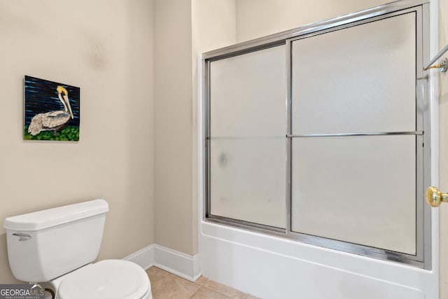 bathroom with toilet, baseboards, combined bath / shower with glass door, and tile patterned floors