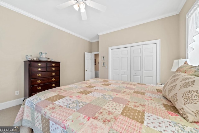 carpeted bedroom with a closet, crown molding, baseboards, and ceiling fan