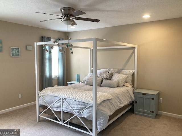 bedroom with light carpet, a textured ceiling, and baseboards