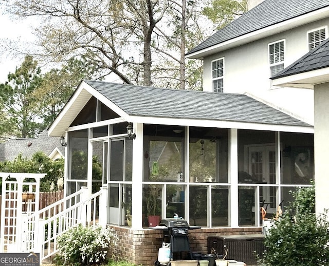 view of outbuilding featuring a sunroom and fence