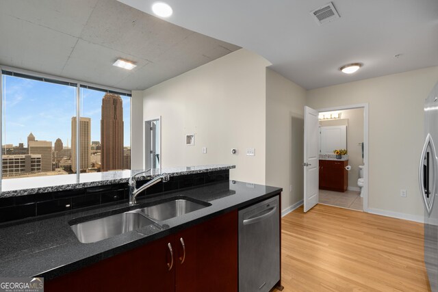 400 W Peachtree St NW Unit 3204, Atlanta, GA 30308 - kitchen with stainless steel dishwasher, light wood-type flooring, and dark stone countertops