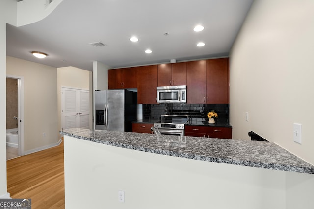 400 W Peachtree St NW Unit 3204, Atlanta, GA 30308 - kitchen featuring stainless steel appliances, light wood finished floors, backsplash, recessed lighting, and a peninsula
