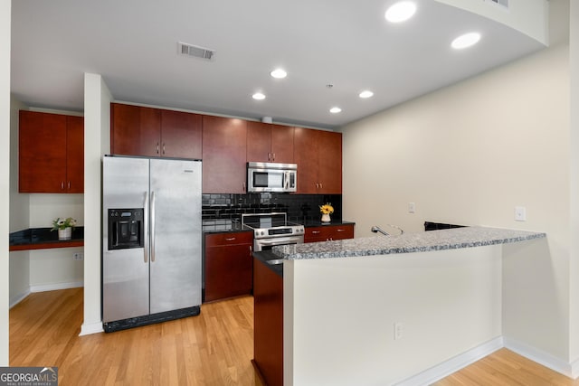 400 W Peachtree St NW Unit 3204, Atlanta, GA 30308 - kitchen featuring stainless steel appliances, a peninsula, light wood-style floors, decorative backsplash, and recessed lighting