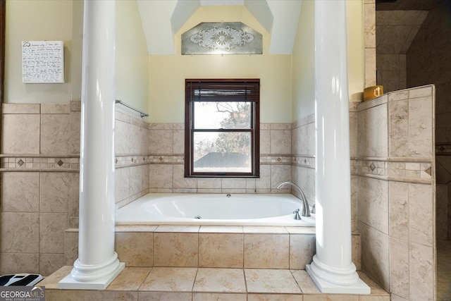 bathroom with a garden tub and decorative columns