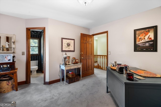 bedroom featuring light carpet, ensuite bath, and baseboards