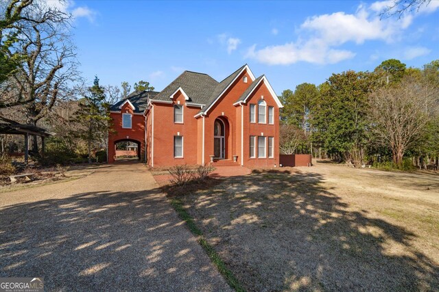 traditional-style house with driveway and brick siding