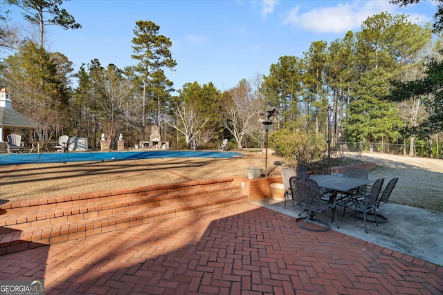 pool with fence, outdoor dining area, and a patio