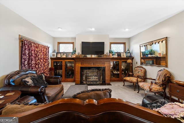 carpeted living room with a fireplace with flush hearth and a wealth of natural light