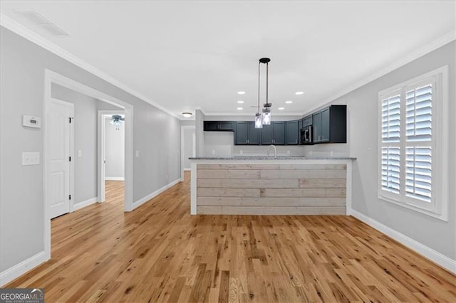 kitchen with light countertops, ornamental molding, light wood-type flooring, and baseboards