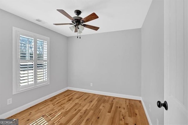 empty room with visible vents, a ceiling fan, light wood-style flooring, and baseboards