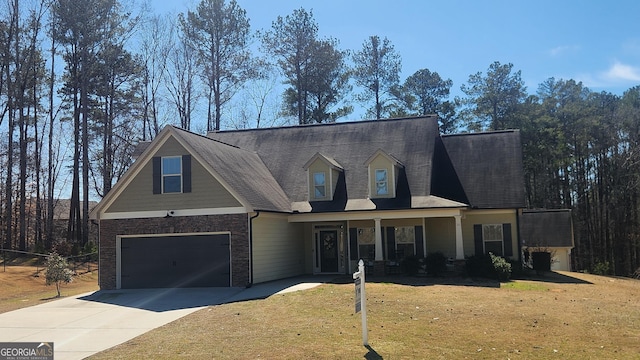 view of front of house with an attached garage, driveway, brick siding, and a front yard