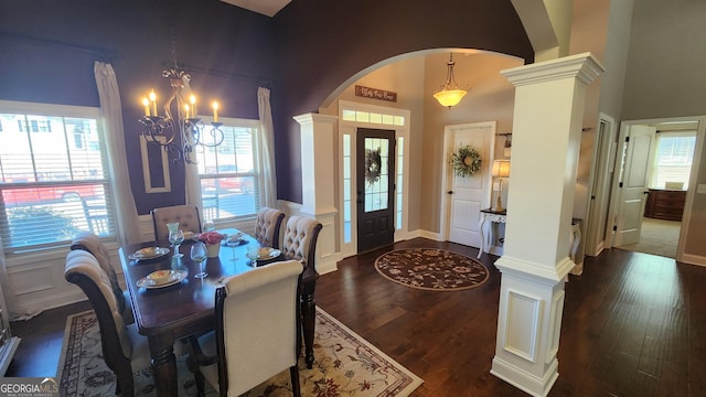 dining room with arched walkways, a notable chandelier, dark wood-type flooring, wainscoting, and ornate columns