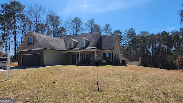 view of front of home with a garage, brick siding, driveway, and a front lawn