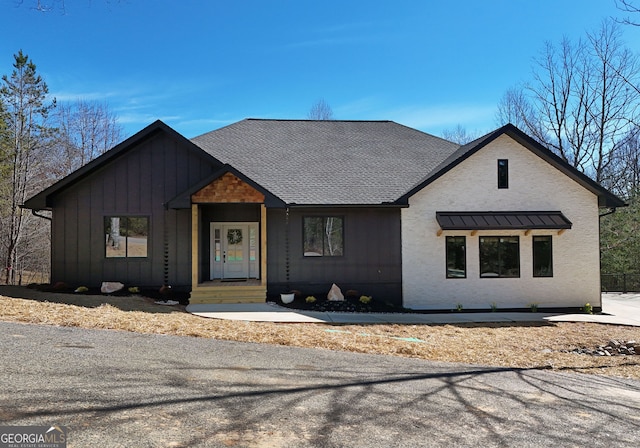 modern farmhouse featuring a shingled roof and board and batten siding