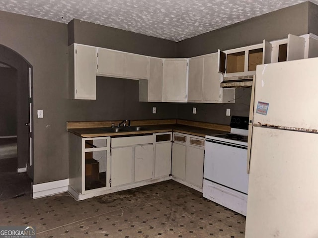 kitchen with arched walkways, white cabinetry, a textured ceiling, white appliances, and under cabinet range hood