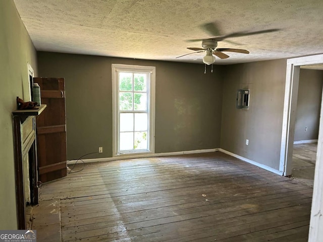 unfurnished living room with a textured ceiling, a fireplace, baseboards, and hardwood / wood-style floors