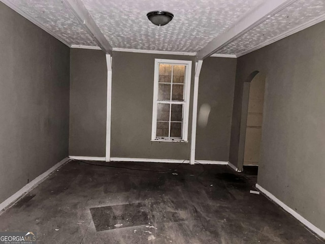 empty room with arched walkways and baseboards