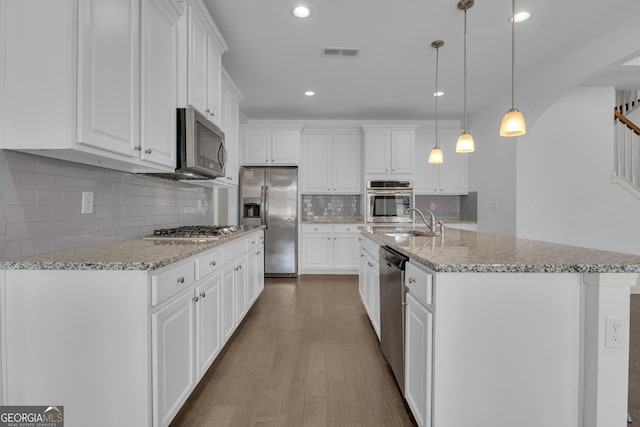 kitchen with appliances with stainless steel finishes, visible vents, a sink, and white cabinetry