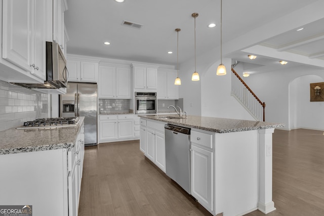 kitchen featuring appliances with stainless steel finishes, visible vents, white cabinetry, and wood finished floors