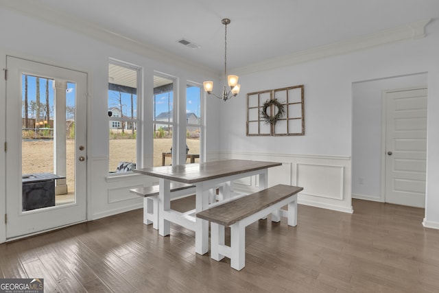 dining room with crown molding, plenty of natural light, visible vents, and an inviting chandelier