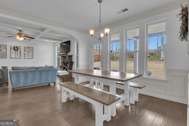 dining room with dark wood-type flooring, coffered ceiling, visible vents, wainscoting, and beamed ceiling