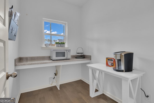 interior space featuring dark wood-style flooring and baseboards