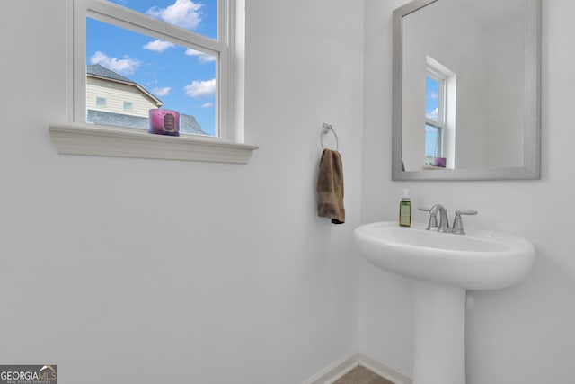 bathroom with a sink, a wealth of natural light, and baseboards