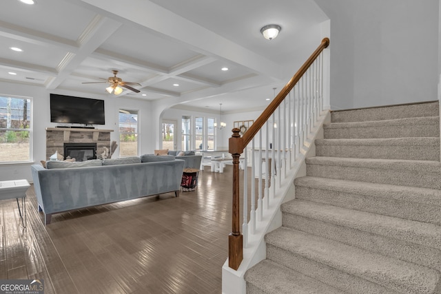 living area featuring stairs, beam ceiling, and wood finished floors