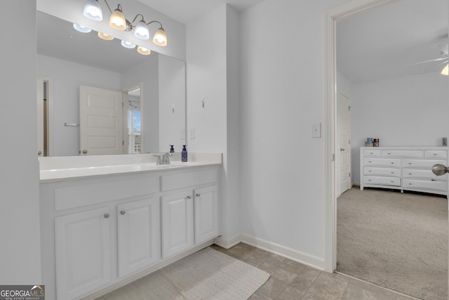 bathroom featuring stone finish floor, vanity, a ceiling fan, and baseboards