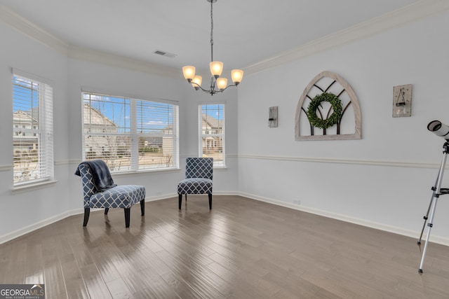 sitting room featuring a chandelier, wood finished floors, visible vents, baseboards, and ornamental molding