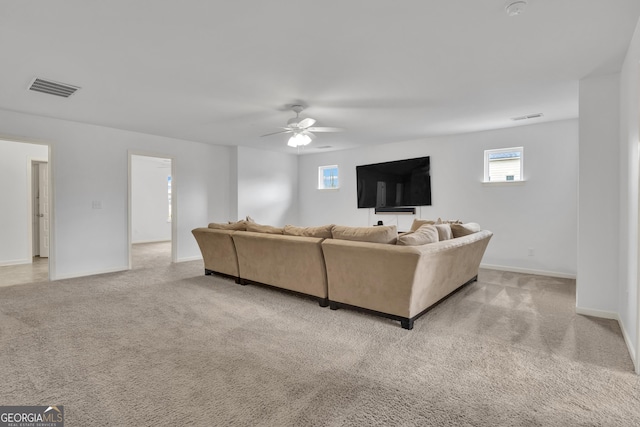 living area with a ceiling fan, carpet, visible vents, and baseboards