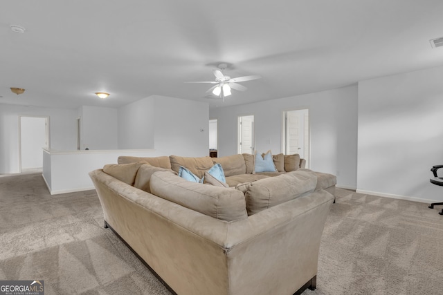 living room featuring light carpet, ceiling fan, visible vents, and baseboards