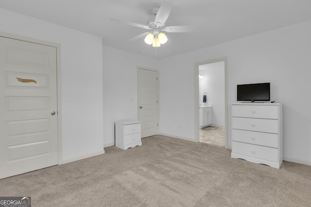 unfurnished bedroom featuring light carpet, connected bathroom, and baseboards