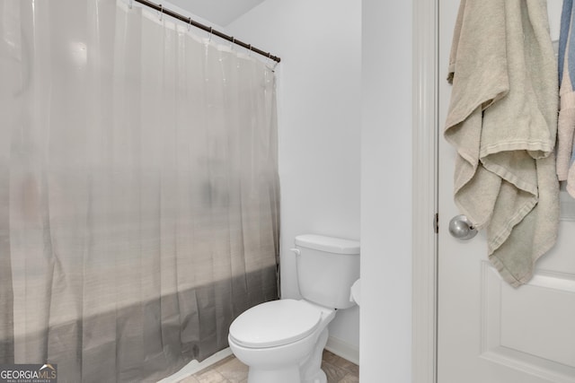 bathroom featuring baseboards, toilet, and a shower with curtain