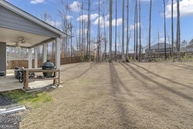 view of yard with ceiling fan and fence