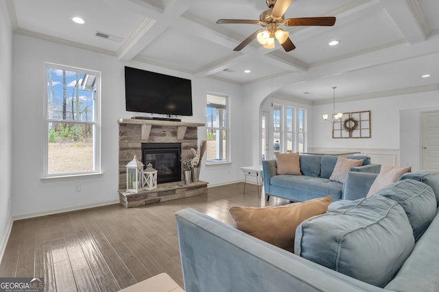 living area featuring arched walkways, visible vents, wood finished floors, coffered ceiling, and beamed ceiling