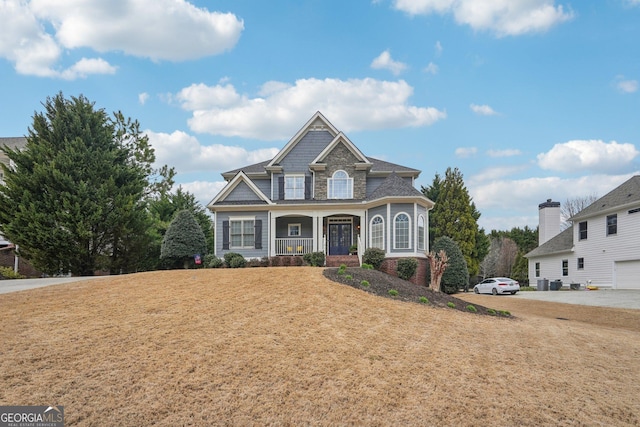 view of front of home featuring covered porch and a front lawn