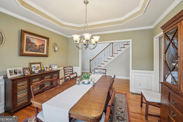 4740 Arbor Meadows Dr, Cumming, GA 30040 - dining area with a tray ceiling, a wainscoted wall, a notable chandelier, and wood finished floors